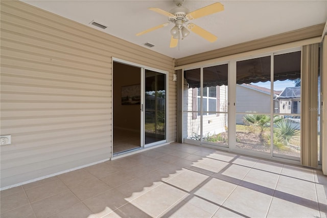 unfurnished sunroom with ceiling fan