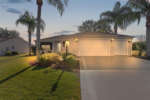 view of front of home with a garage and a lawn