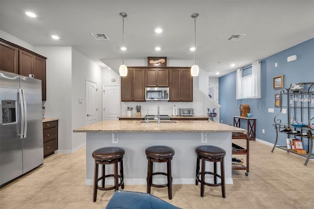 kitchen with dark brown cabinetry, visible vents, appliances with stainless steel finishes, and a sink