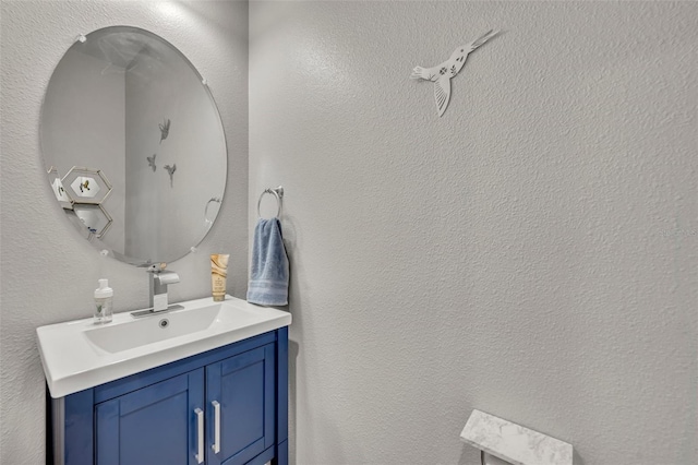 bathroom with vanity and a textured wall