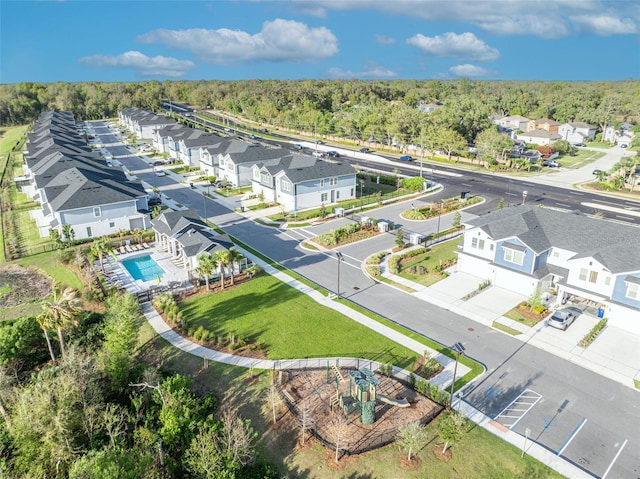 drone / aerial view featuring a residential view and a view of trees