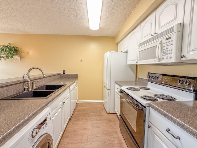 kitchen with sink, white appliances, white cabinets, a textured ceiling, and washer / clothes dryer