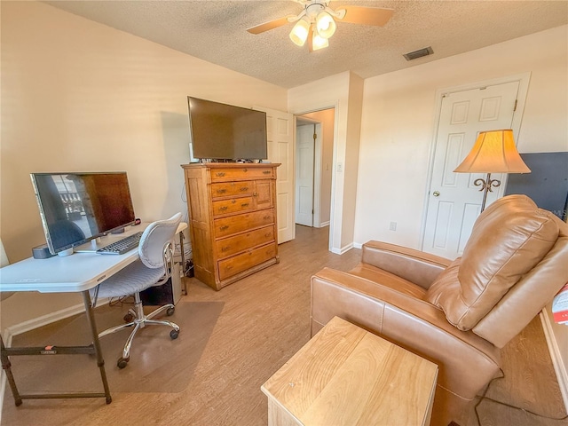 office space with a textured ceiling, light hardwood / wood-style floors, and ceiling fan