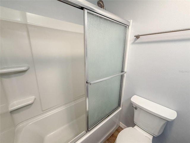 bathroom featuring shower / bath combination with glass door and toilet