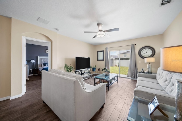 living room featuring ceiling fan and a textured ceiling