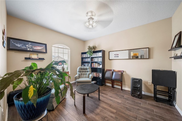 sitting room with ceiling fan, a textured ceiling, and dark hardwood / wood-style flooring