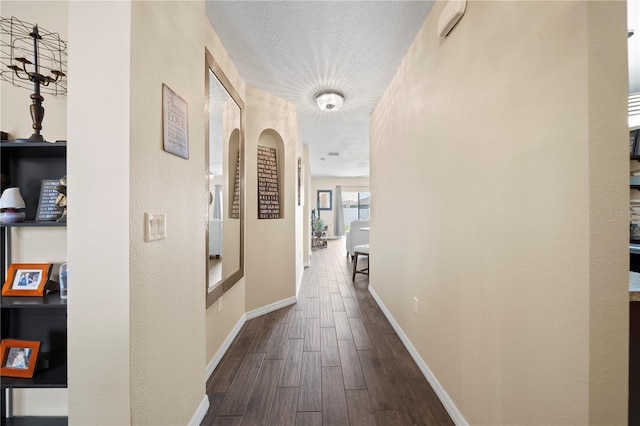 hallway with dark hardwood / wood-style flooring and a textured ceiling