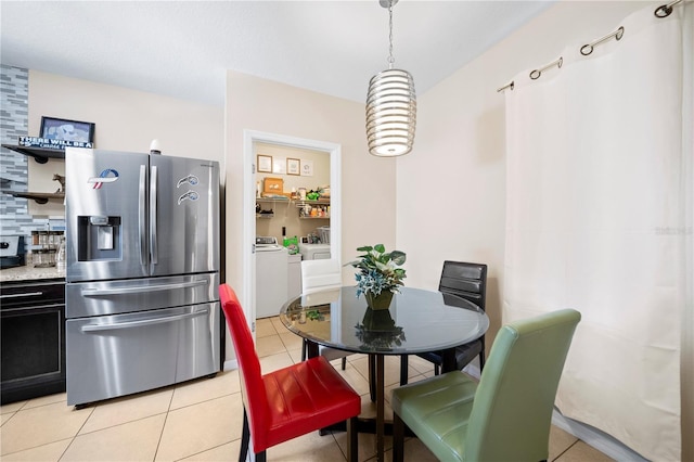 tiled dining area with washer and clothes dryer