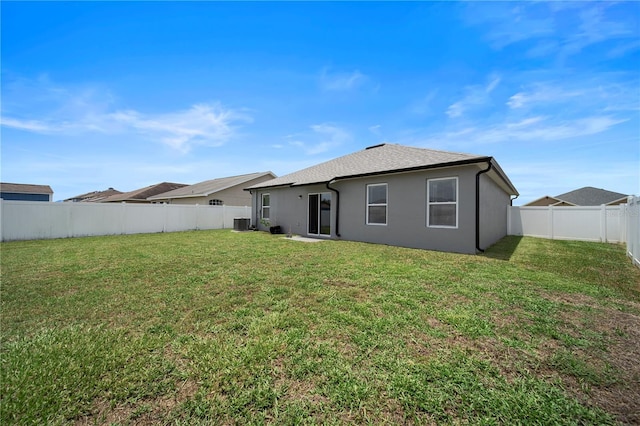 rear view of property featuring a yard and central AC