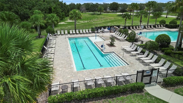 view of pool with a patio and a lawn