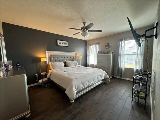 bedroom featuring baseboards, a textured ceiling, and dark wood finished floors