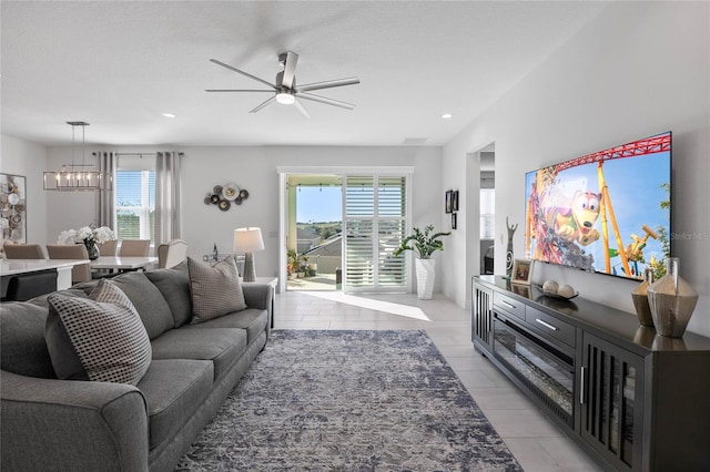 living room with ceiling fan with notable chandelier and a textured ceiling