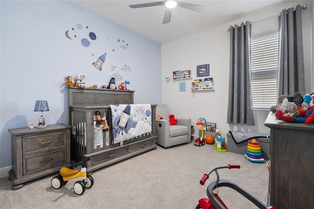 carpeted bedroom featuring ceiling fan, multiple windows, and a crib