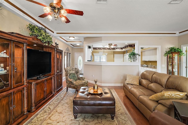 living room featuring crown molding, ceiling fan, and light hardwood / wood-style floors