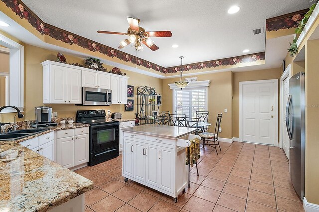 kitchen with sink, white cabinetry, hanging light fixtures, stainless steel appliances, and a center island