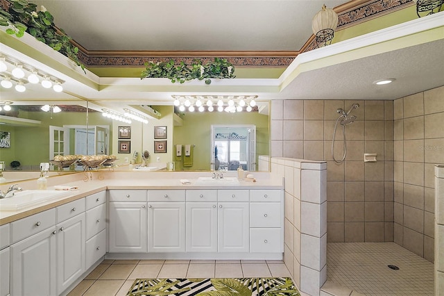 bathroom with vanity, ornamental molding, tile patterned floors, and tiled shower