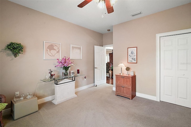 interior space featuring light colored carpet and ceiling fan