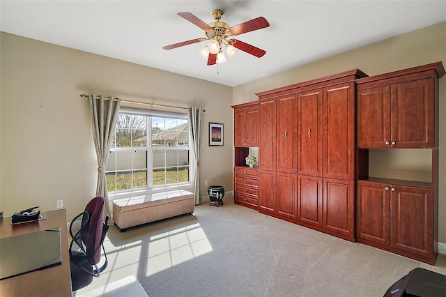 carpeted office space featuring ceiling fan