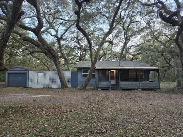 view of front facade featuring a garage, a porch, and an outdoor structure