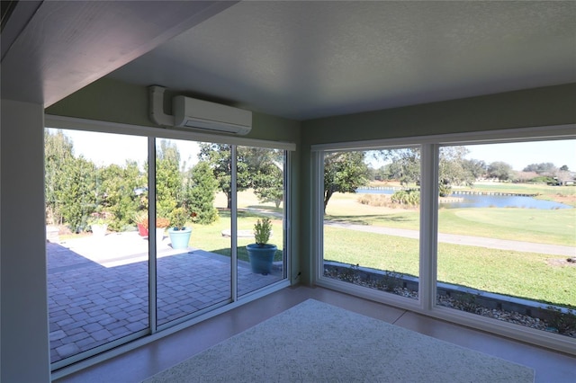 unfurnished sunroom with a water view and a wall mounted AC