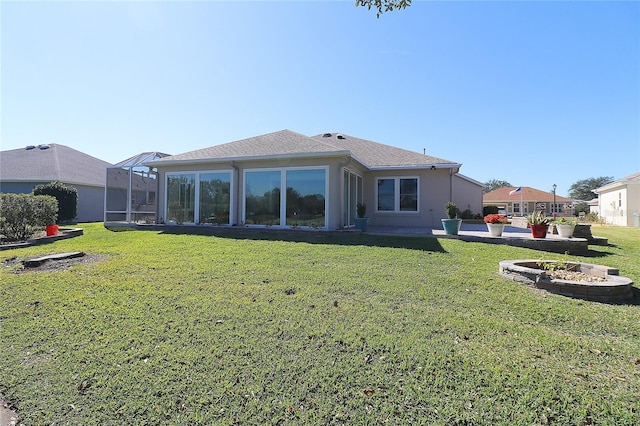 back of house featuring a yard, glass enclosure, and a patio area