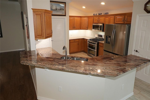 kitchen with sink, stainless steel appliances, a breakfast bar, and kitchen peninsula