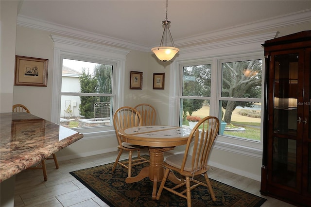 tiled dining area featuring ornamental molding and plenty of natural light