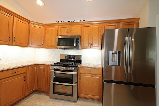 kitchen with lofted ceiling, light stone countertops, decorative backsplash, and stainless steel appliances