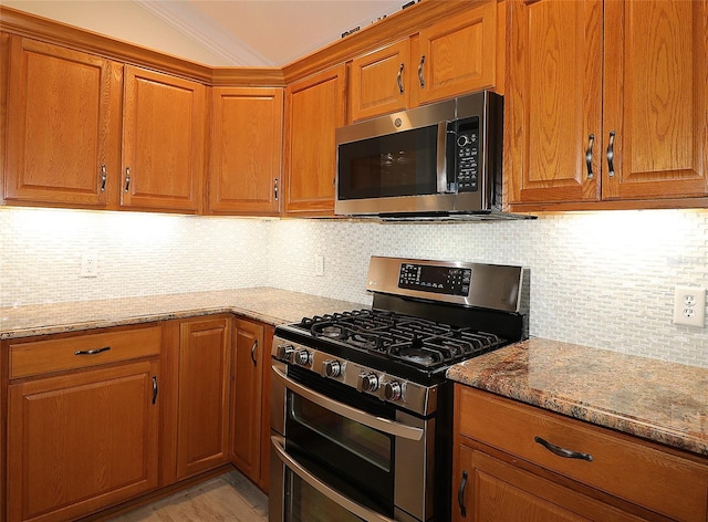 kitchen featuring light stone countertops, appliances with stainless steel finishes, and backsplash