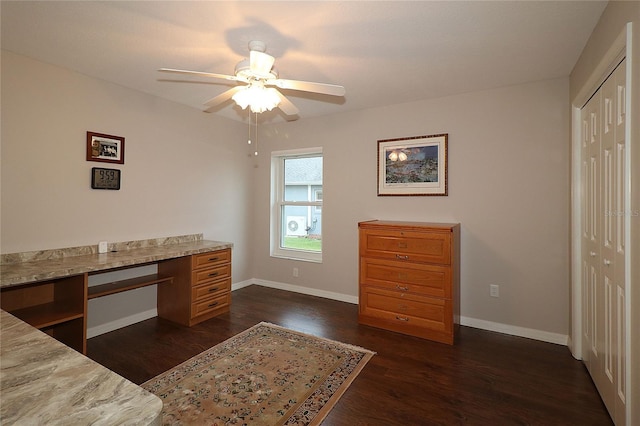 unfurnished office with ceiling fan and dark hardwood / wood-style flooring