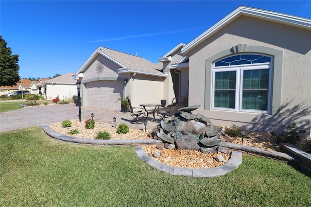 view of side of property with a garage and a lawn