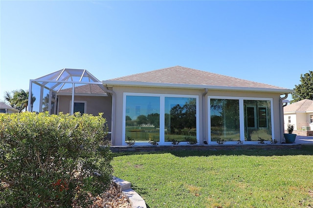 back of property with a lanai and a lawn