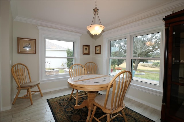 dining space with crown molding, light wood-type flooring, and a wealth of natural light