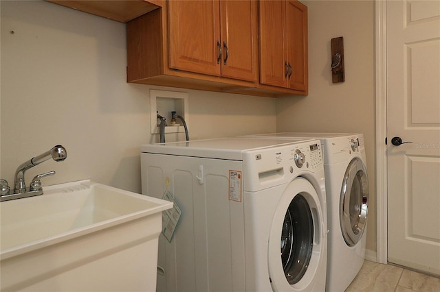 washroom with cabinets, separate washer and dryer, and sink