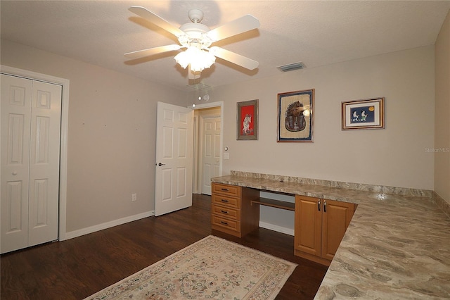 unfurnished office with ceiling fan, dark hardwood / wood-style floors, and a textured ceiling