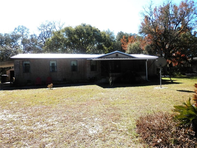 rear view of house with a carport and a lawn