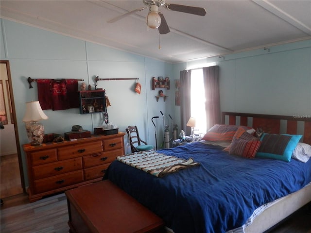 bedroom with ornamental molding, lofted ceiling, hardwood / wood-style floors, and ceiling fan