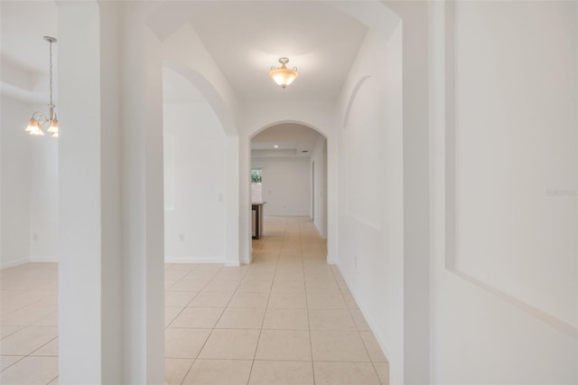 hallway featuring light tile patterned floors and a chandelier