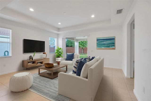 living room featuring a raised ceiling and light tile patterned floors