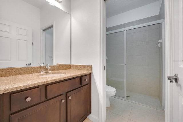 bathroom featuring vanity, tile patterned flooring, a shower with door, and toilet