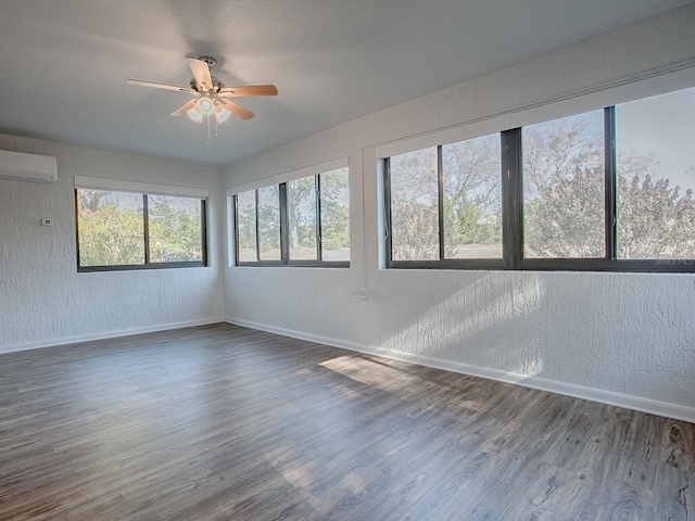 empty room with an AC wall unit, dark hardwood / wood-style floors, and ceiling fan