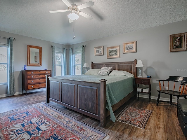 bedroom featuring dark wood-type flooring, ceiling fan, and a textured ceiling