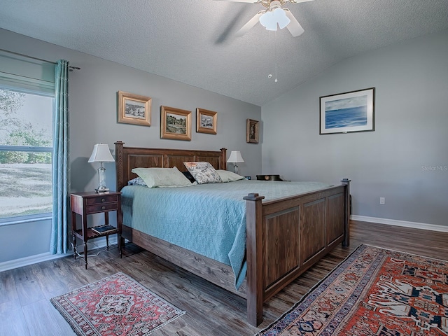 bedroom with hardwood / wood-style flooring, ceiling fan, vaulted ceiling, and a textured ceiling