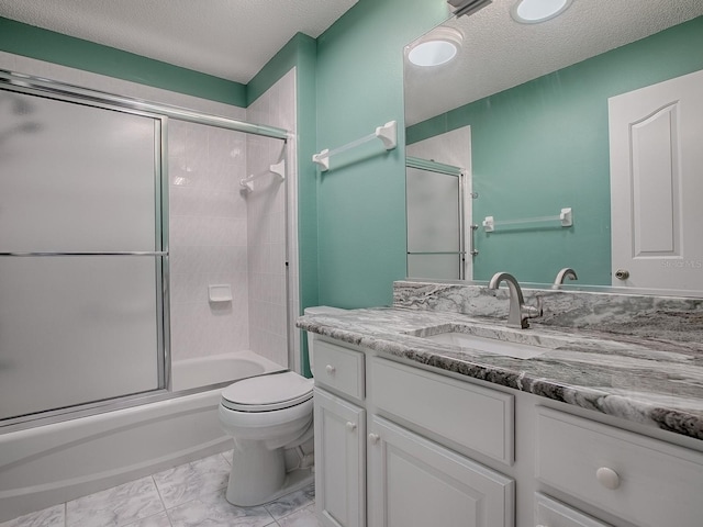 full bathroom featuring vanity, a textured ceiling, bath / shower combo with glass door, and toilet