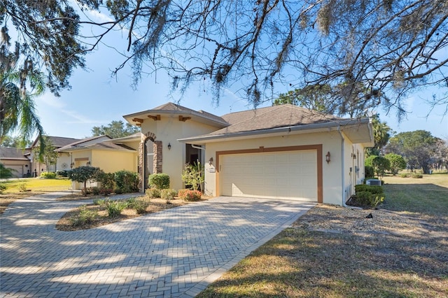 view of front of house featuring a garage and central AC