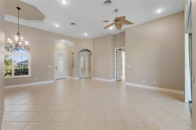 spare room featuring a raised ceiling, ceiling fan with notable chandelier, and light tile patterned floors