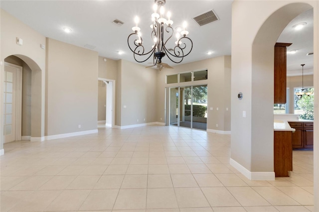 tiled spare room with a notable chandelier and a healthy amount of sunlight