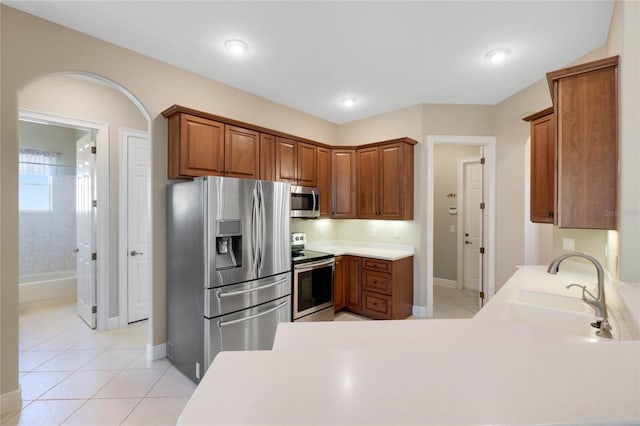 kitchen with appliances with stainless steel finishes, sink, and light tile patterned floors