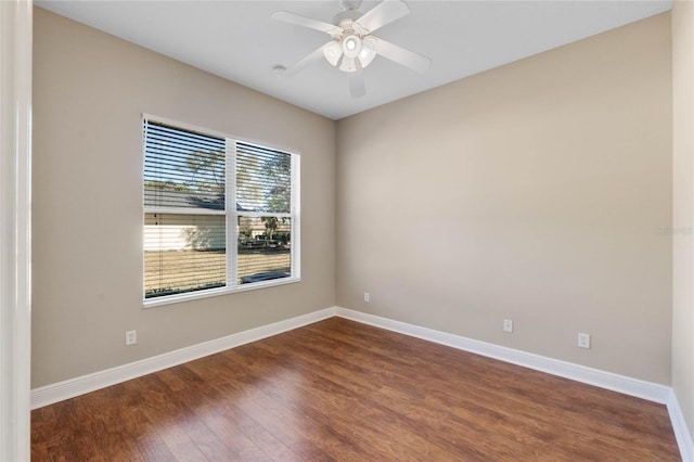 spare room with dark hardwood / wood-style flooring and ceiling fan