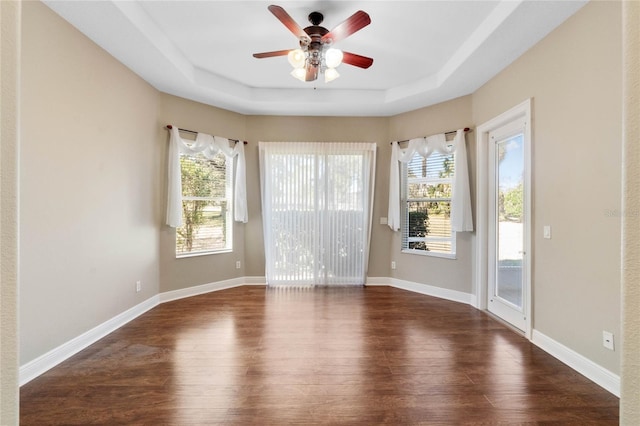 spare room featuring ceiling fan, dark hardwood / wood-style flooring, and a tray ceiling